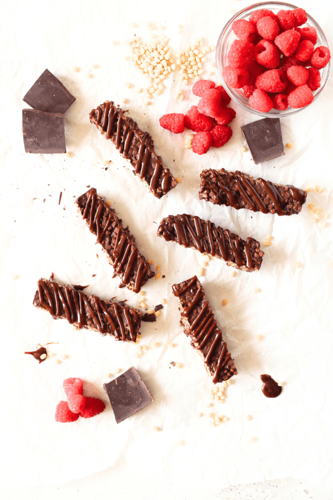 top view of copycat Keto Crunch Bars with raspberries and chocolate scattered