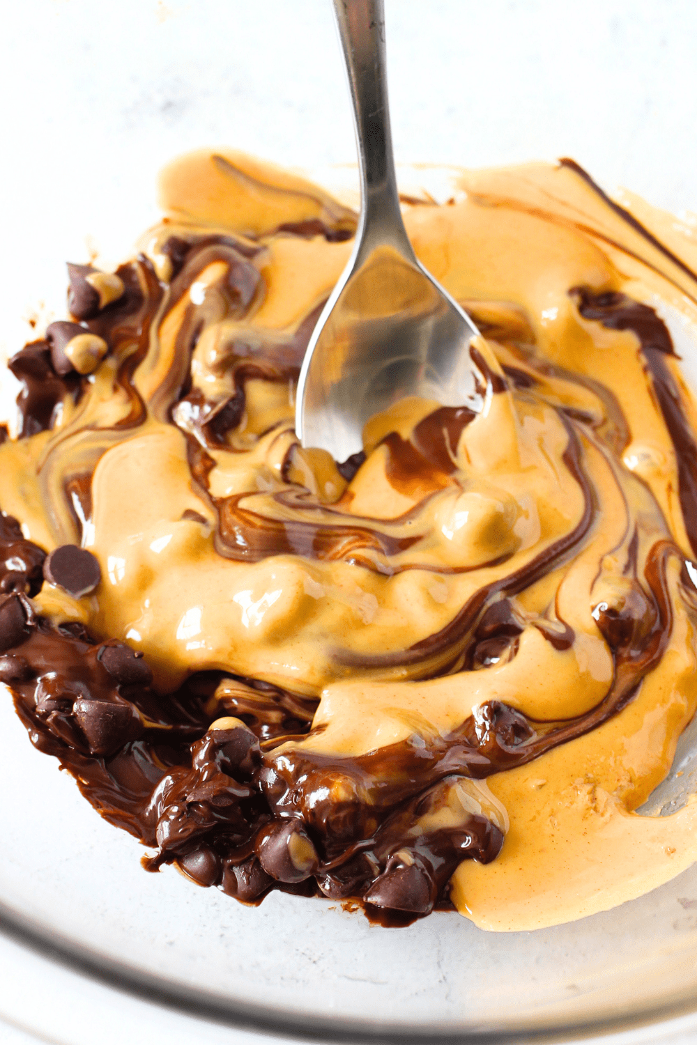 4-ingredient keto bar with sugar-free chocolate, peanut butter, coconut oil and high protein cereal being mixed in a bowl.