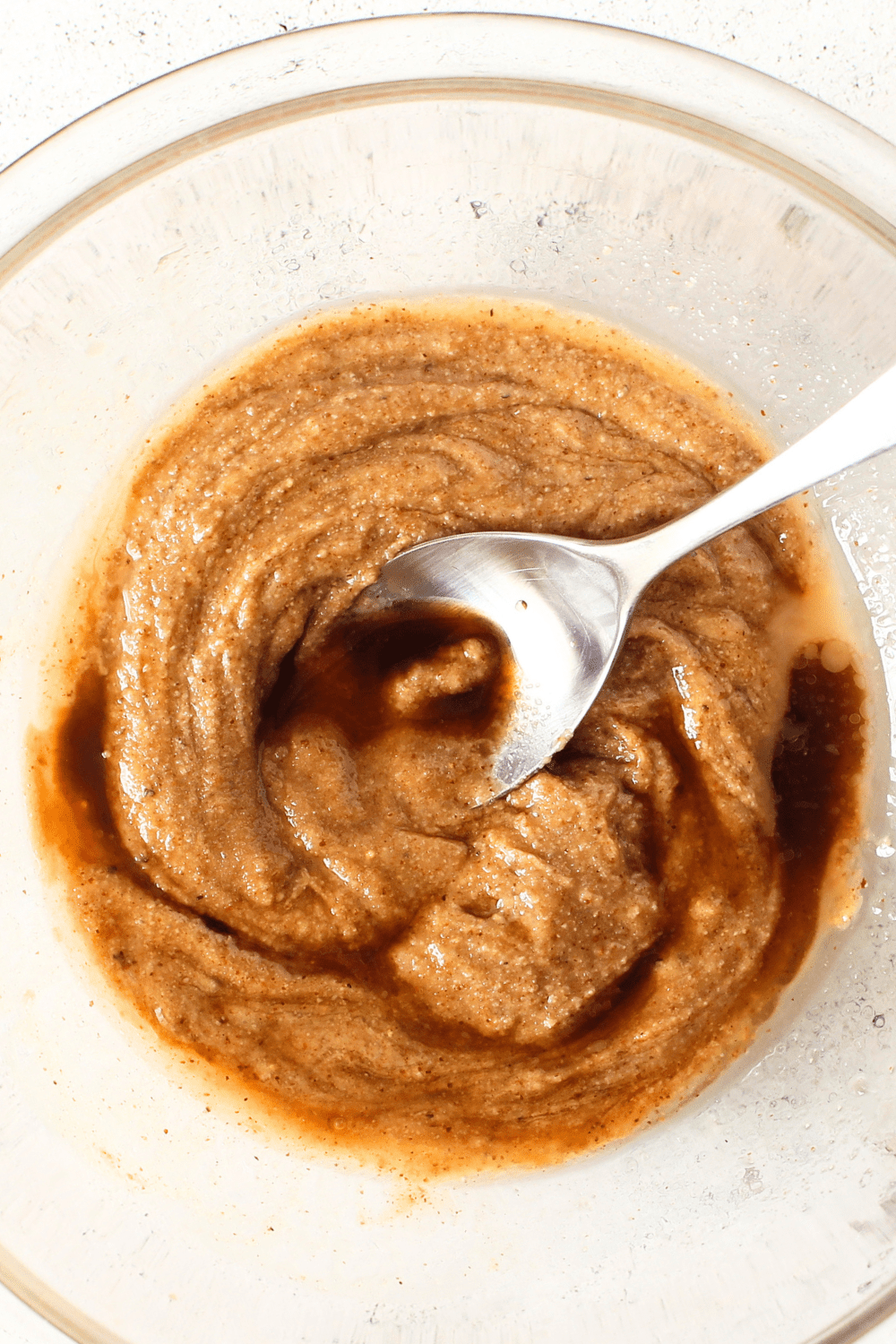 top view of a bowl with homemade protein bar liquid ingredients including almond butter