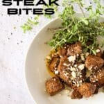 air fryer carnivore steak bites with crumbled blue cheese in a white bowl with crumbled blue cheese on top