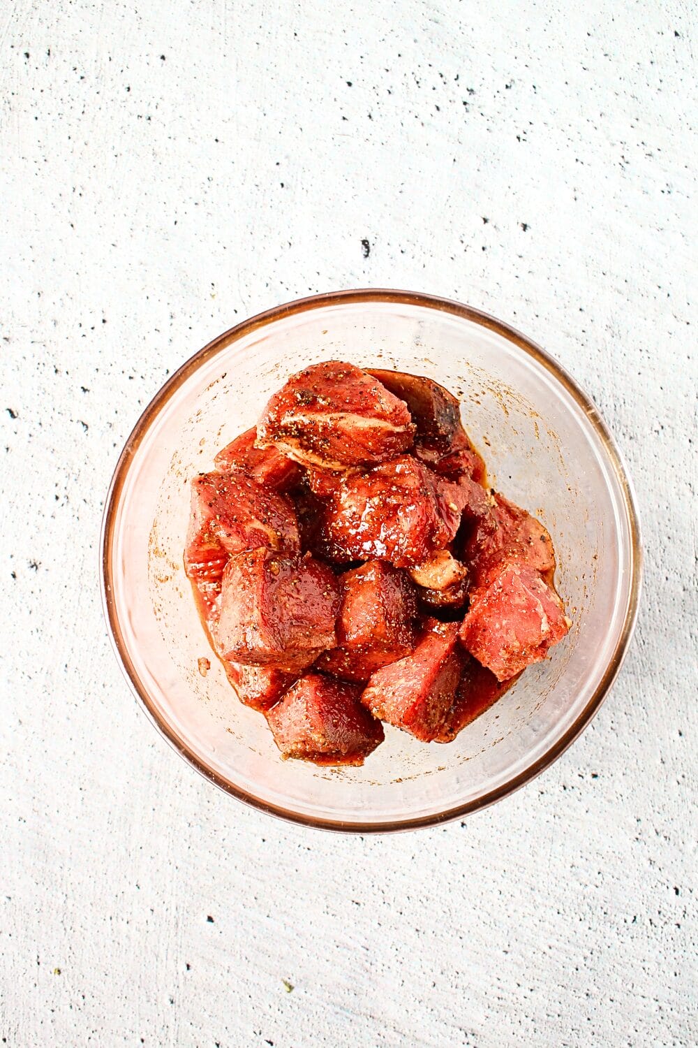 glass bowl with cuts of steak and spices for making a PSMF air fryer steak recipe