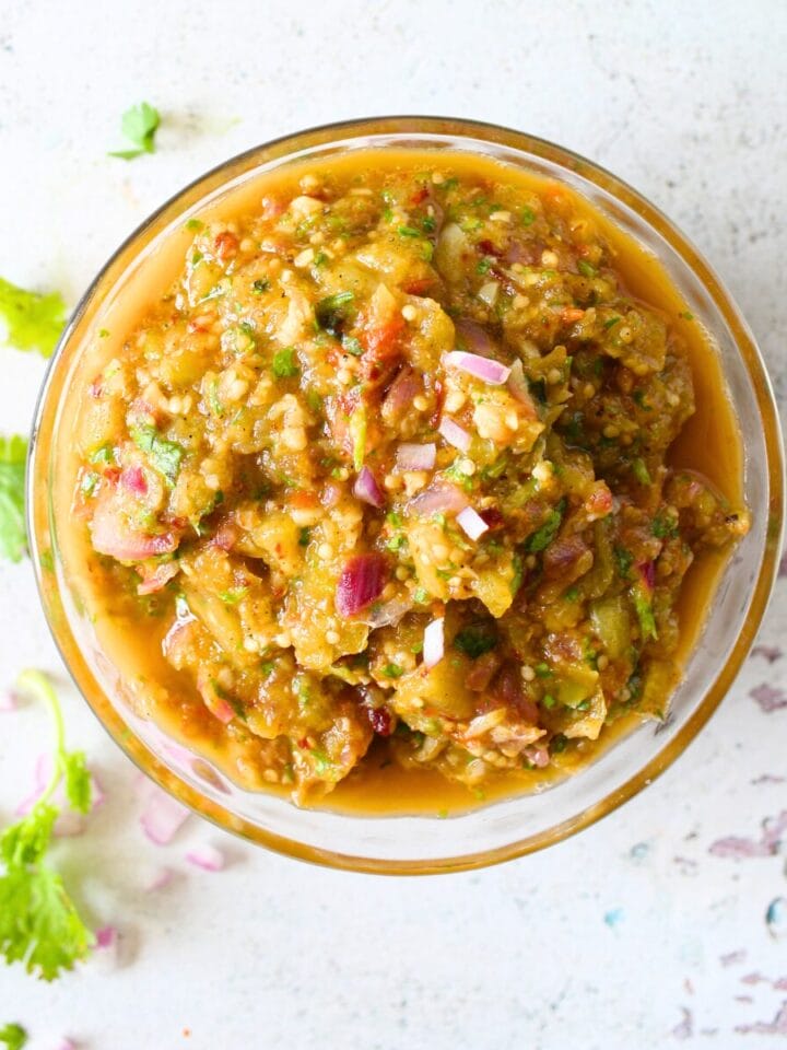 top view of a bowl with healthy Chipotle tomatillo chili salsa with fresh cilantro in the background