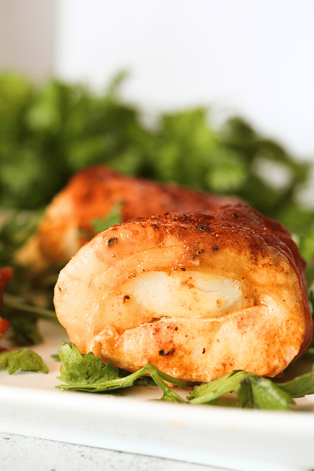 a piece of PSMF cod recipe on a serving platter with fresh herbs