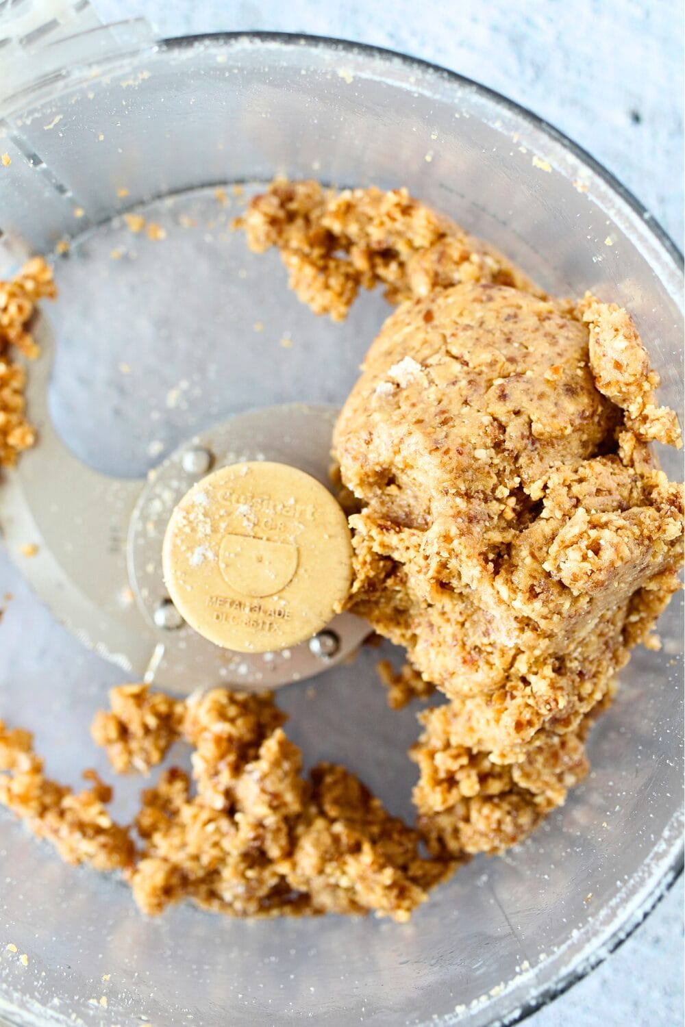 top view of a food processor with easy cashew balls ingredients ready to be rolled into cashew cookie bites