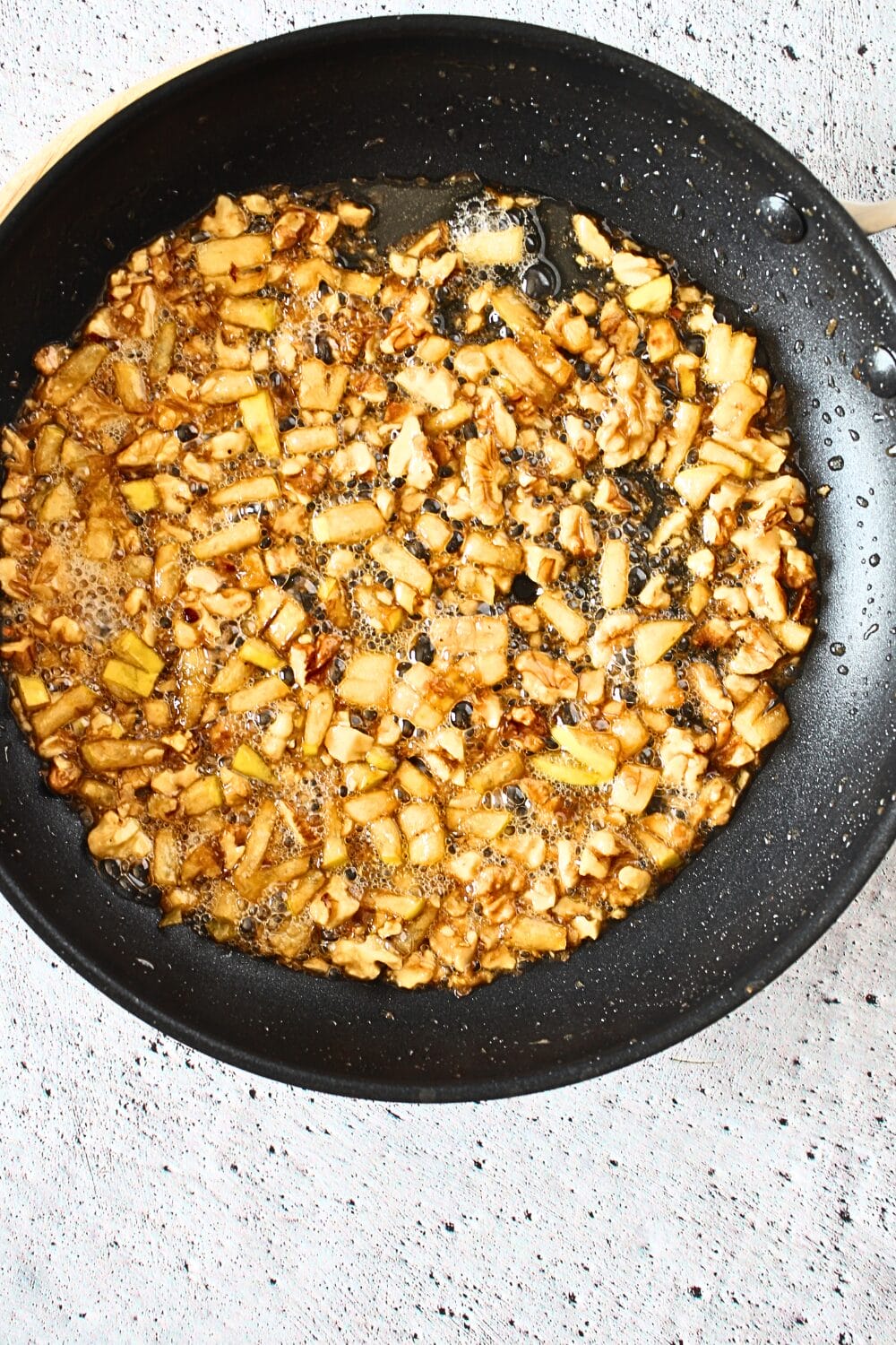 top view of frying pan with keto caramel apple nut filling for cookie cups