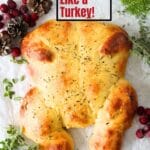 easy keto bread shaped like a turkey with cranberries and pinecones scattered about