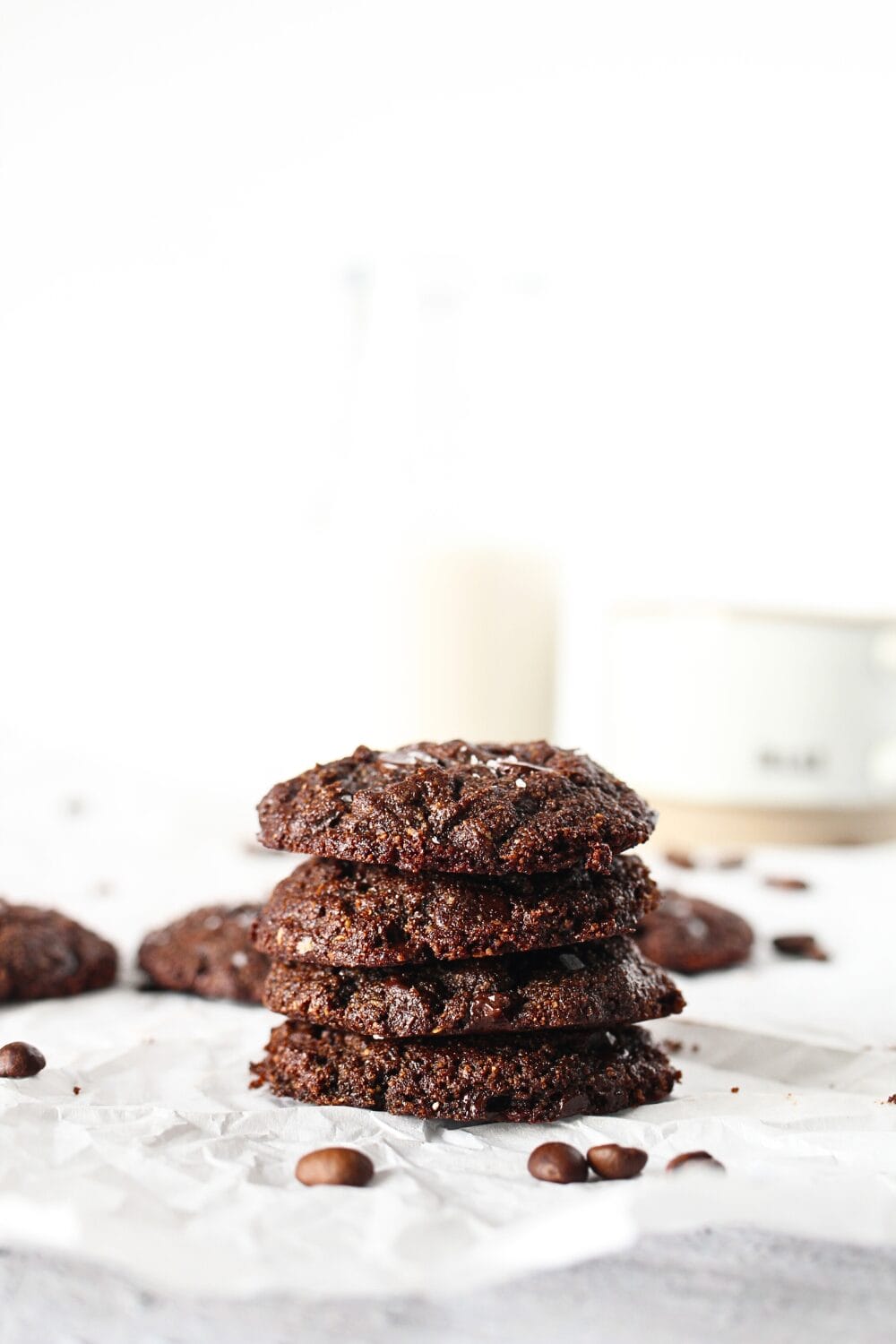 3 keto chocolate espresso chip cookies stacked on top of each other with a glass of almond milk