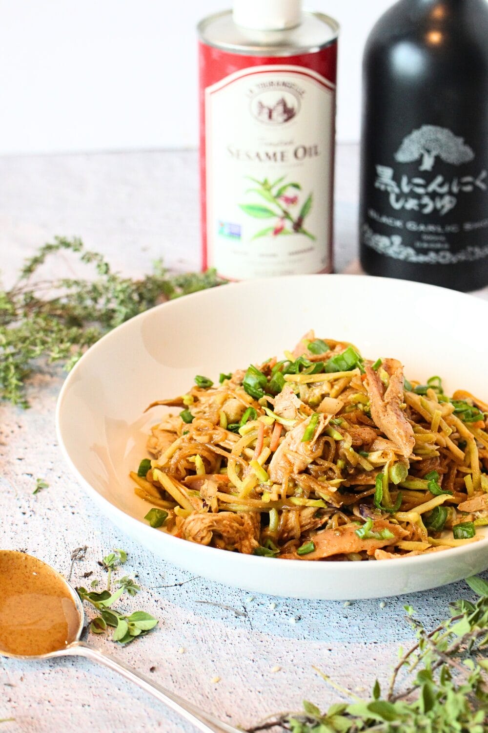 front view of a keto dinner recipe for one using shirataki noodles, almond butter and soy sauce.  Soy sauce and sesame oil are in the background.
