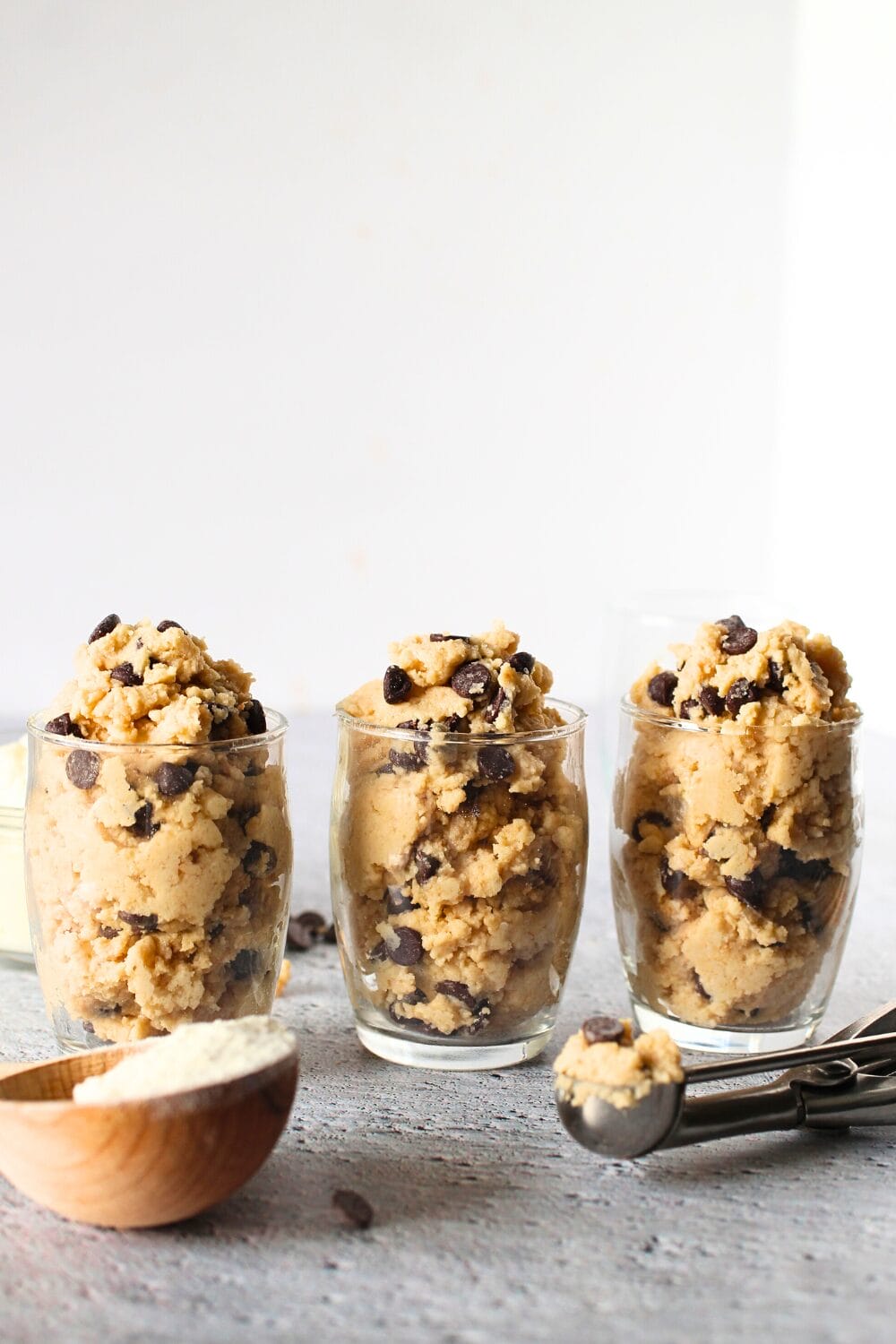 3 glasses filled with super healthy high protein cookie dough made with keto and sugar-free ingredients and protein powder