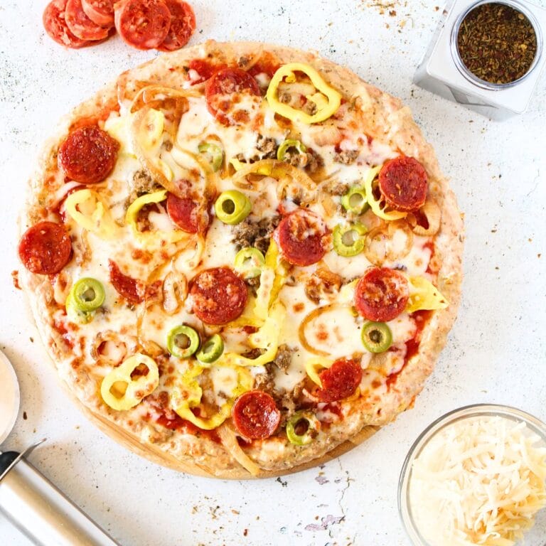 top view of a zero carb pizza crust recipe topped with high protein toppings and pepperoni and cheese on the side