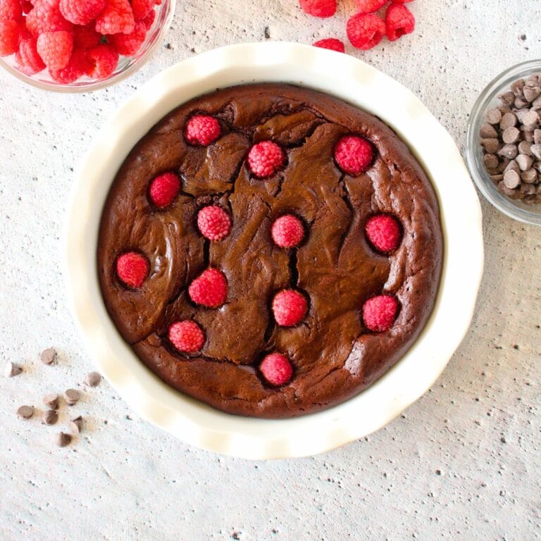 top view of easy keto chocolate molten lava cake with raspberries on top and scattered around the dish