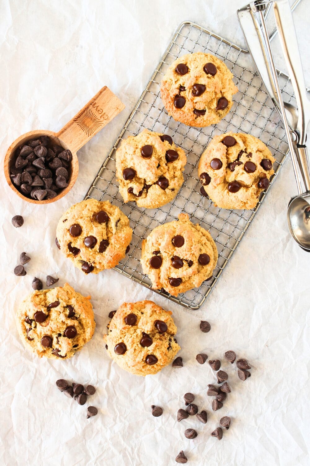 top view of high protein chocolate chip cookies with sugar-free chocoalte chips and a cookie scoop lying to the side