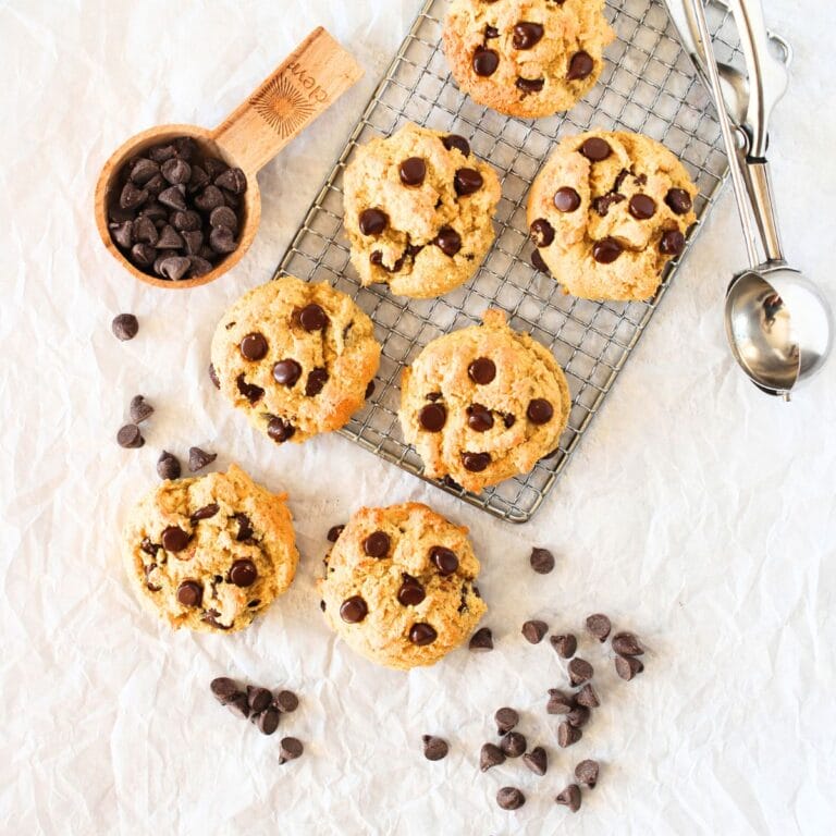 top view of high protein chocolate chip cookies with sugar-free chocoalte chips and a cookie scoop lying to the side
