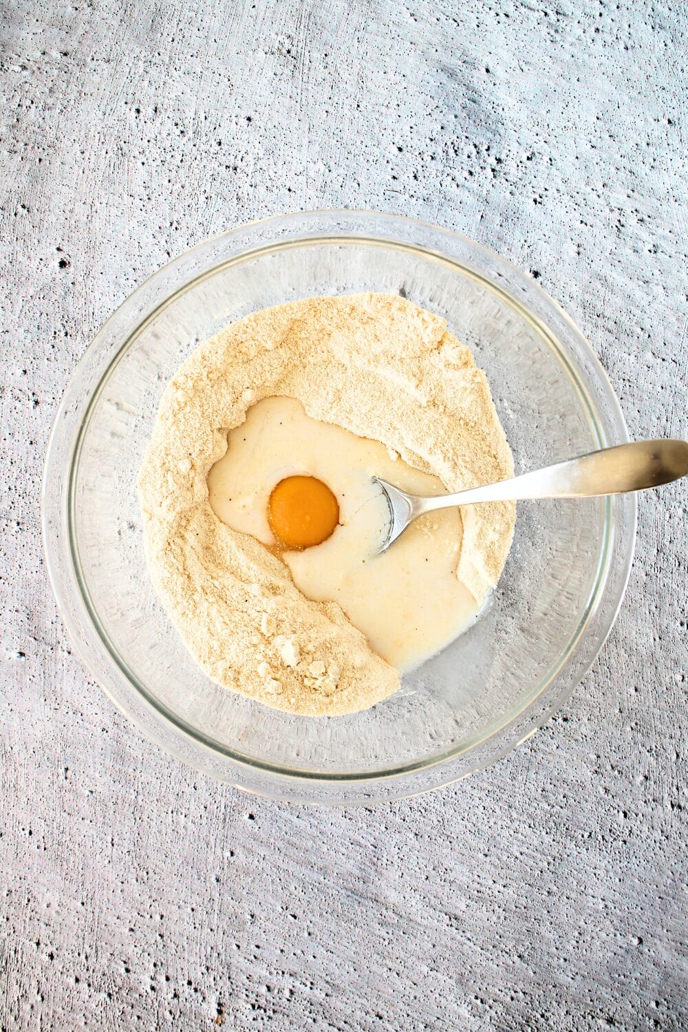 top view of high protein cookie dry ingredients with egg being added