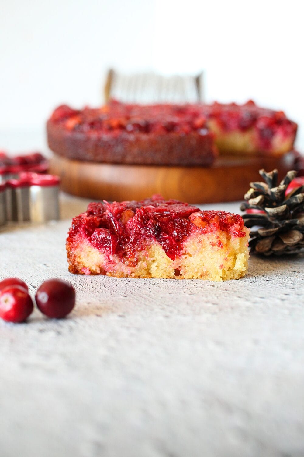 a slice of copycat trader joe's pie with cranberries and walnuts on top and a light vanilla keto sponge cake on the bottom