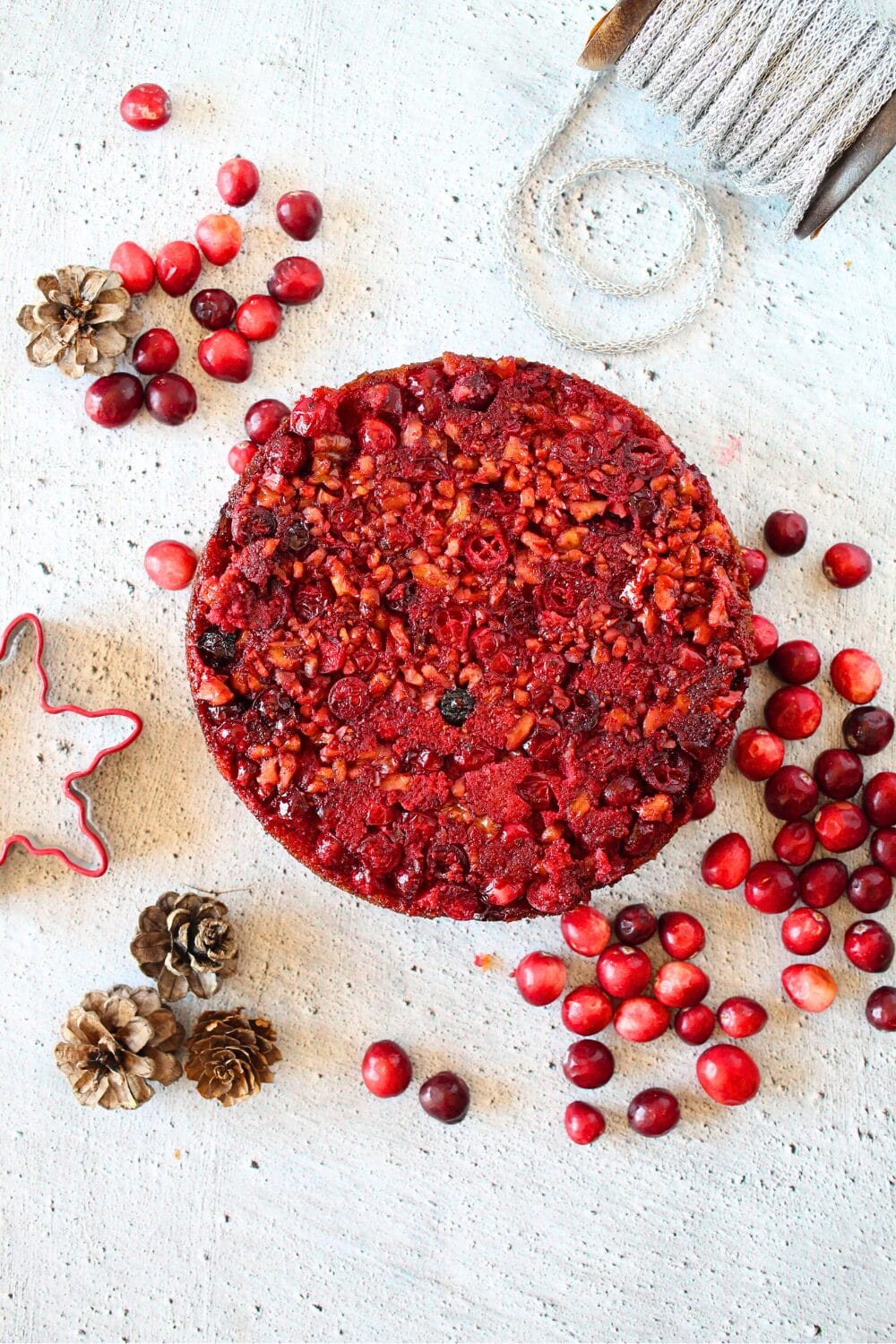 top view of gluten-free cranberry pie with scattered cranberries and holiday decore