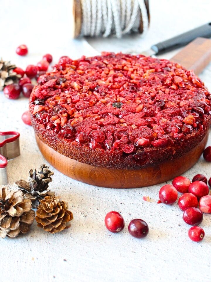 front view of keto cranberry upside down Nantucket pie with holiday decorations scattered around