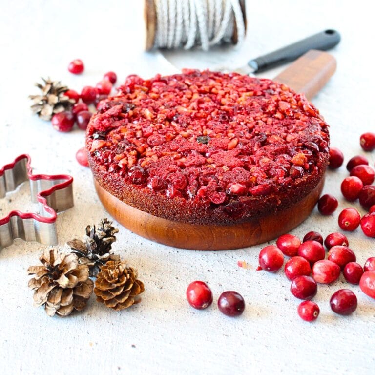 front view of keto cranberry upside down Nantucket pie with holiday decorations scattered around