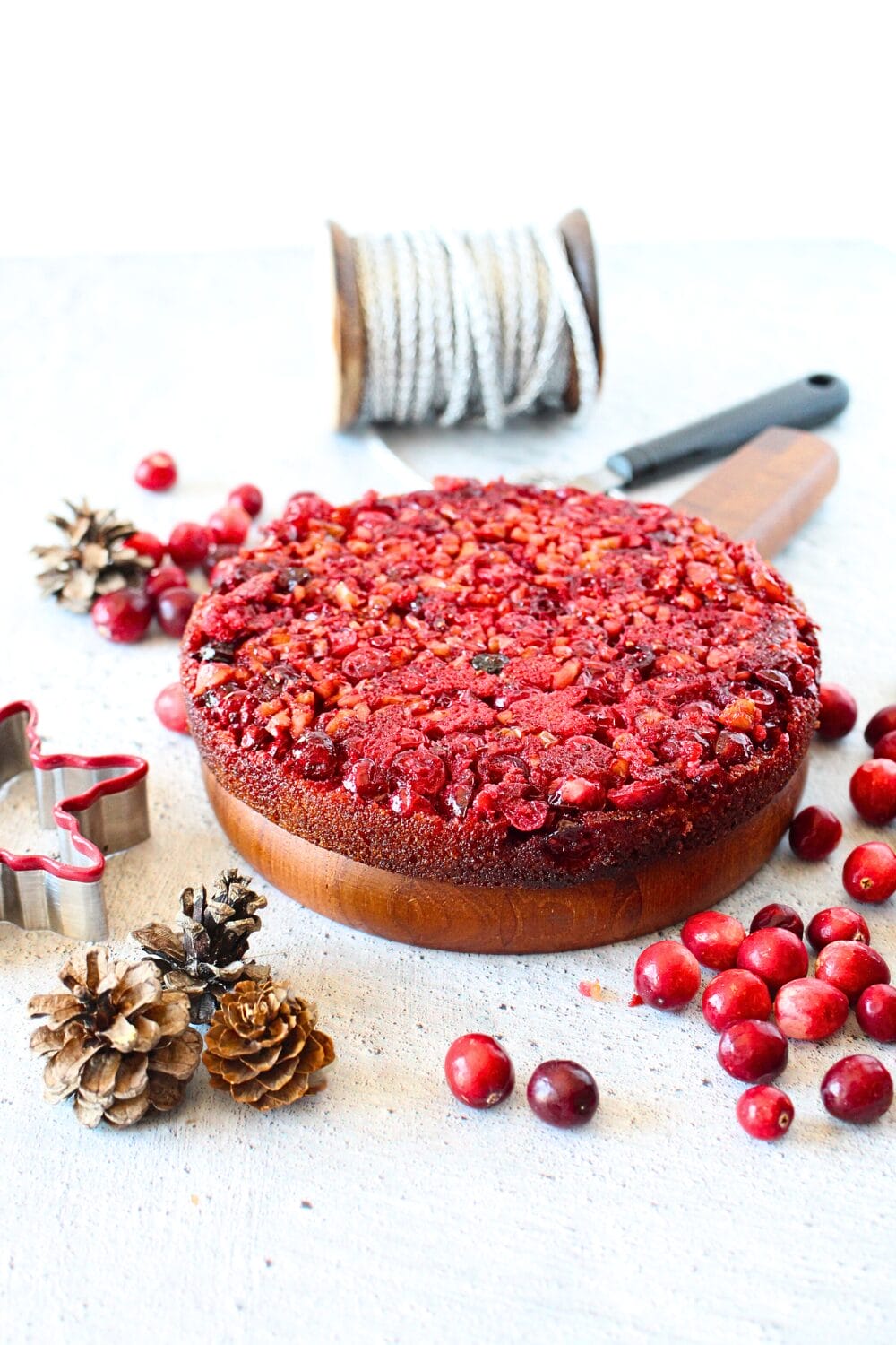 front view of keto cranberry upside down Nantucket pie with holiday decorations scattered around