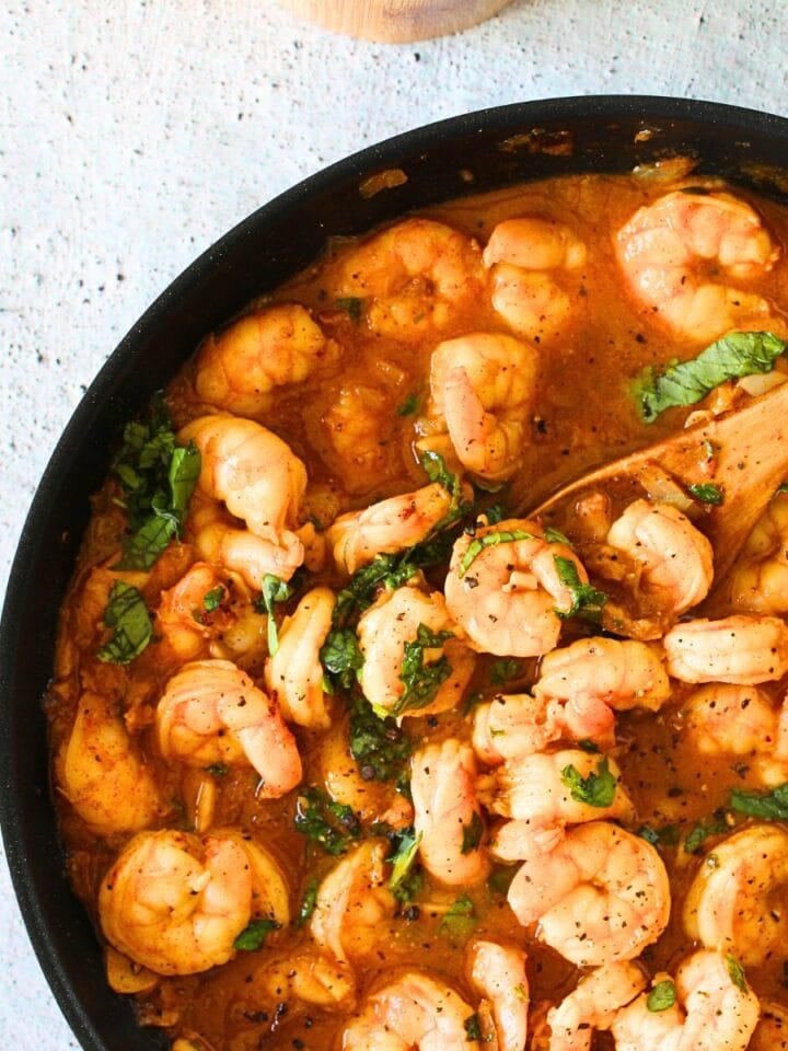 top view of high protein spicy buttered shrimp with a wooden spoon