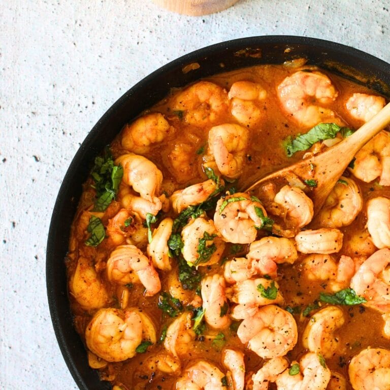 top view of high protein spicy buttered shrimp with a wooden spoon