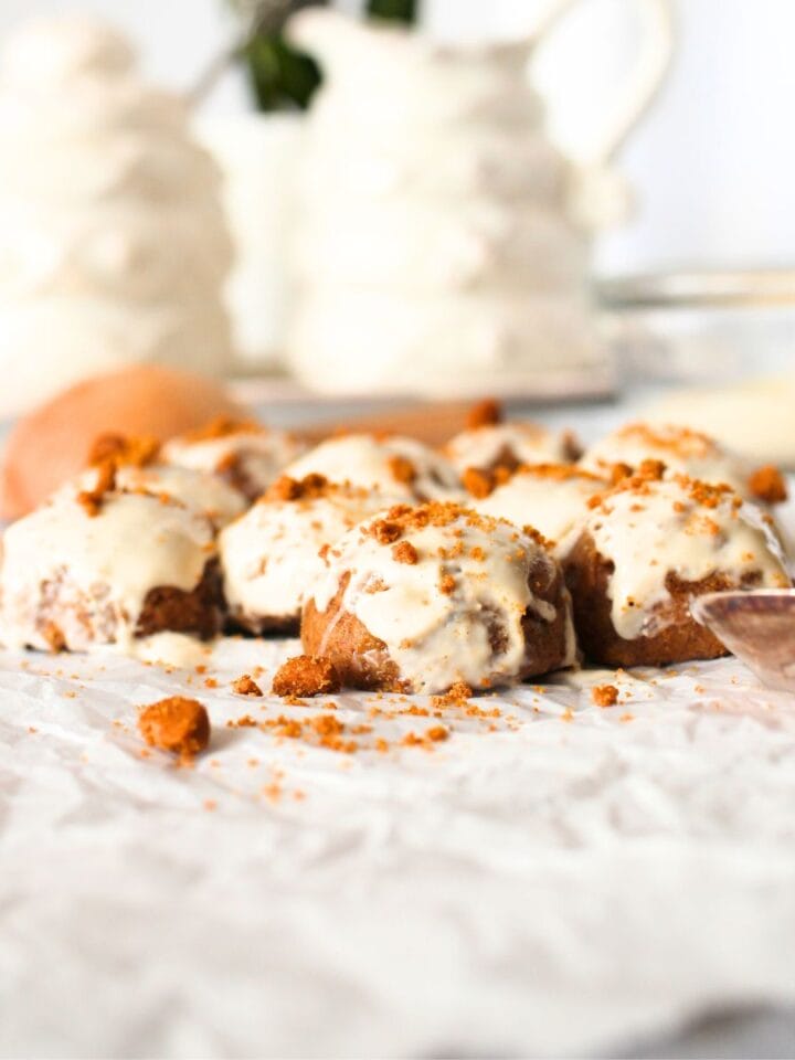 front view of keto speculoos fat bomb truffles with a cream cheese glaze and a tea set in the background