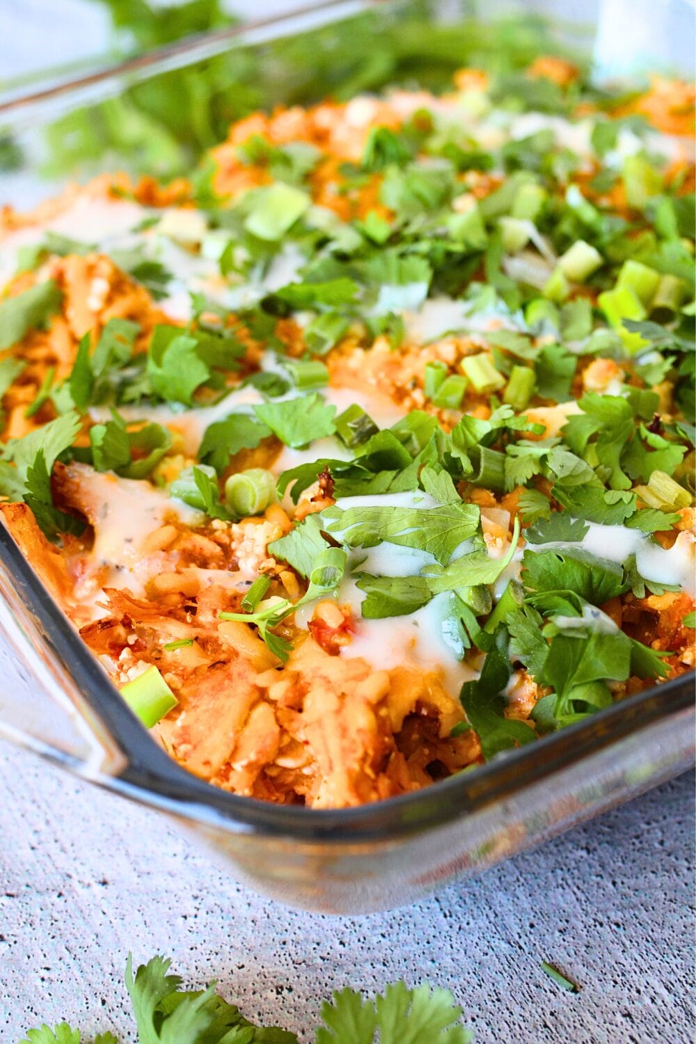 front view of high protein casserole made with chicken breast, hot sauce, riced cauliflower and topped with cilantro