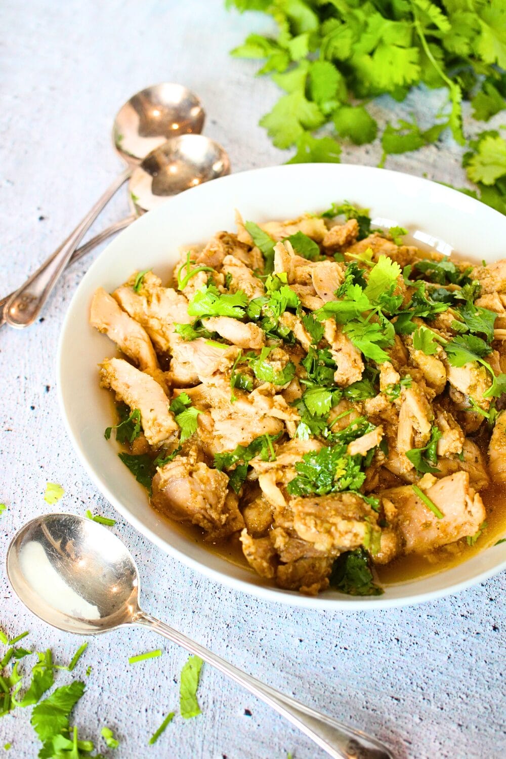 a white bowl filled with keto slow cooker chicken with cilantro
