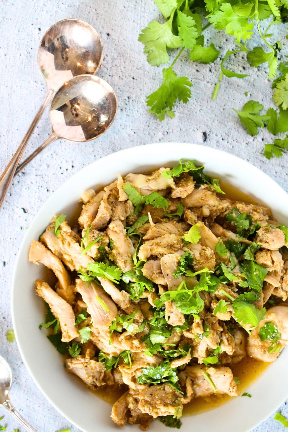 top view of a bowl filled with low carb slow cooker chicken and spoons