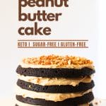 front view of a keto chocolate cake with peanut butter frosting and chopped peanuts on top on a serving platter