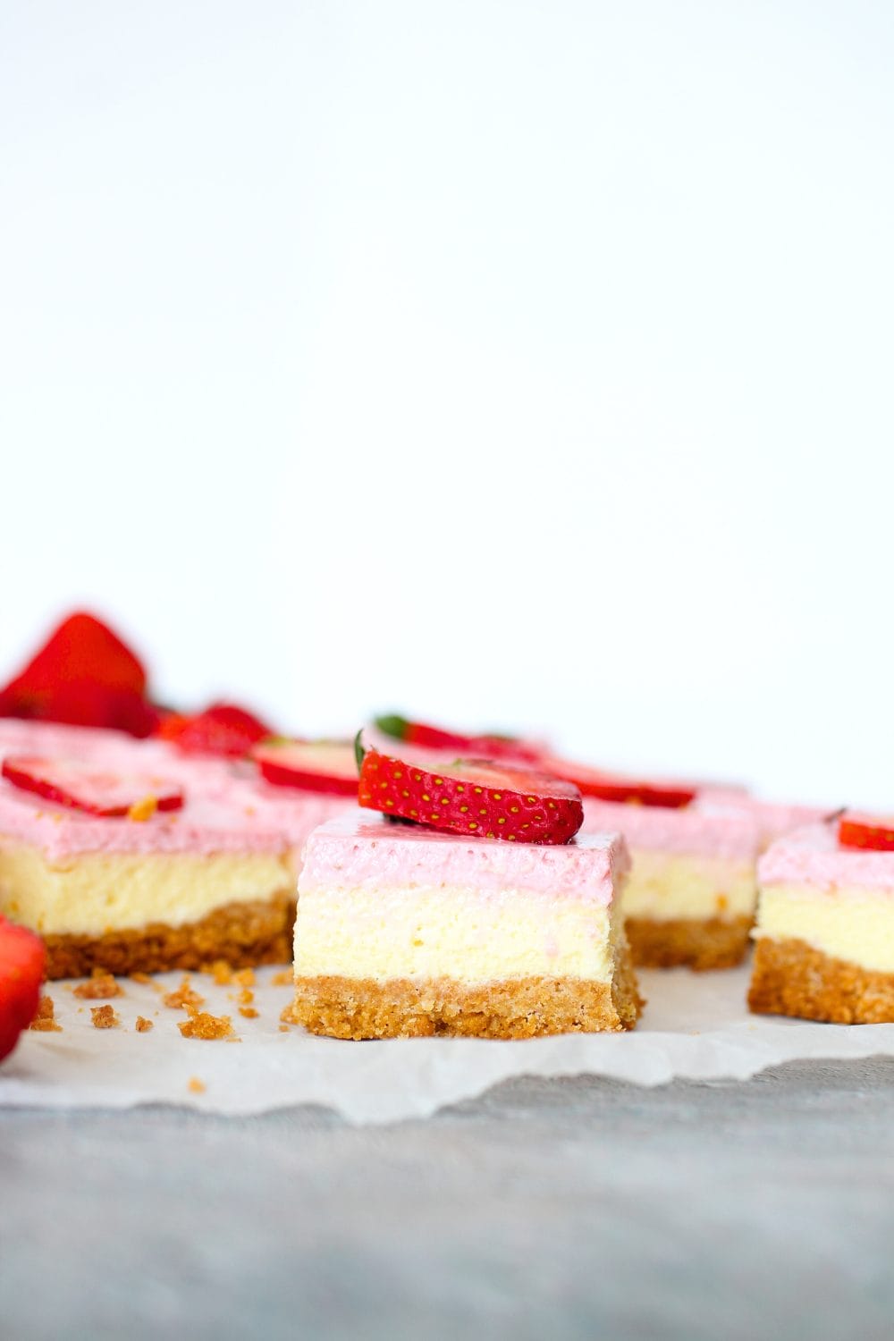 front view of a sugar-free strawberry cheesecake bar topped with a slice of strawberry