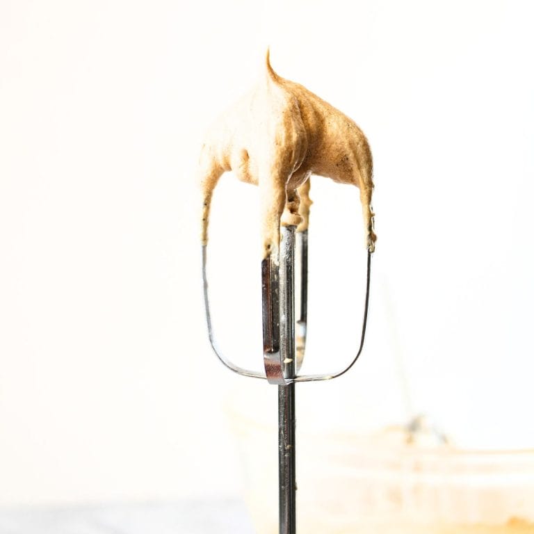 front view of hand held mixer beater with healthy vanilla protein frosting on the tip of the beater
