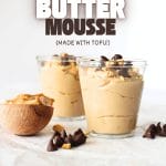front view of two cups filled with high protein vegan peanut butter mousse with peanut butter and sugar-free chocolate chips scattered about