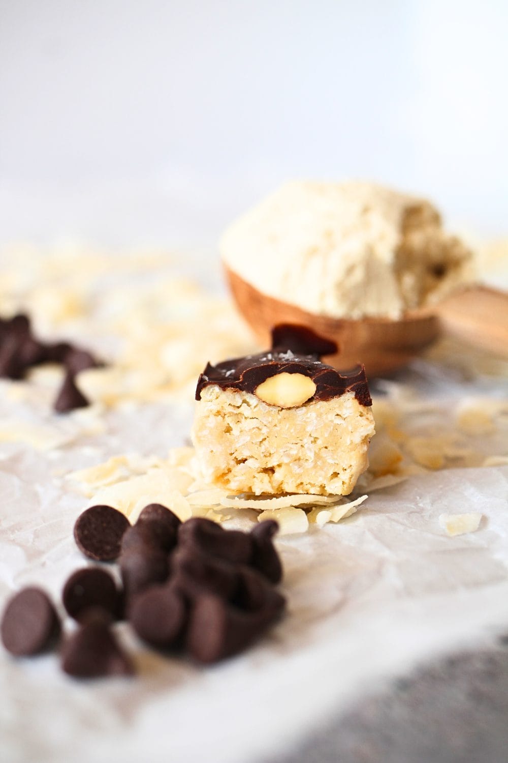 front view of the inside of a keto homemade almond joy protein bar with chocolate chips and protein powder in a spoon