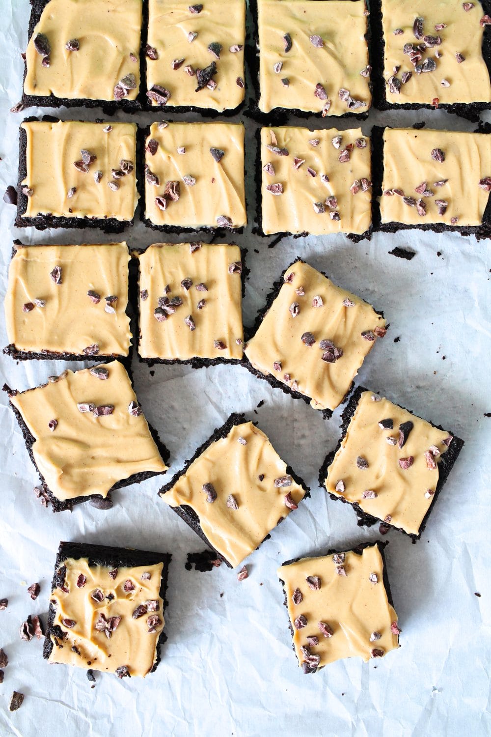 top view of healthy low carb brownies with high protein peanut butter frosting and cocoa nibs sprinkled on top