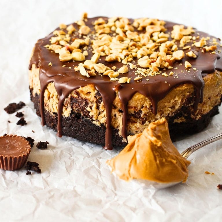 front view of keto peanut butter chocolate cheesecake with a sugar-free Reese's peanut butter cup and a spoonful of peanut butter