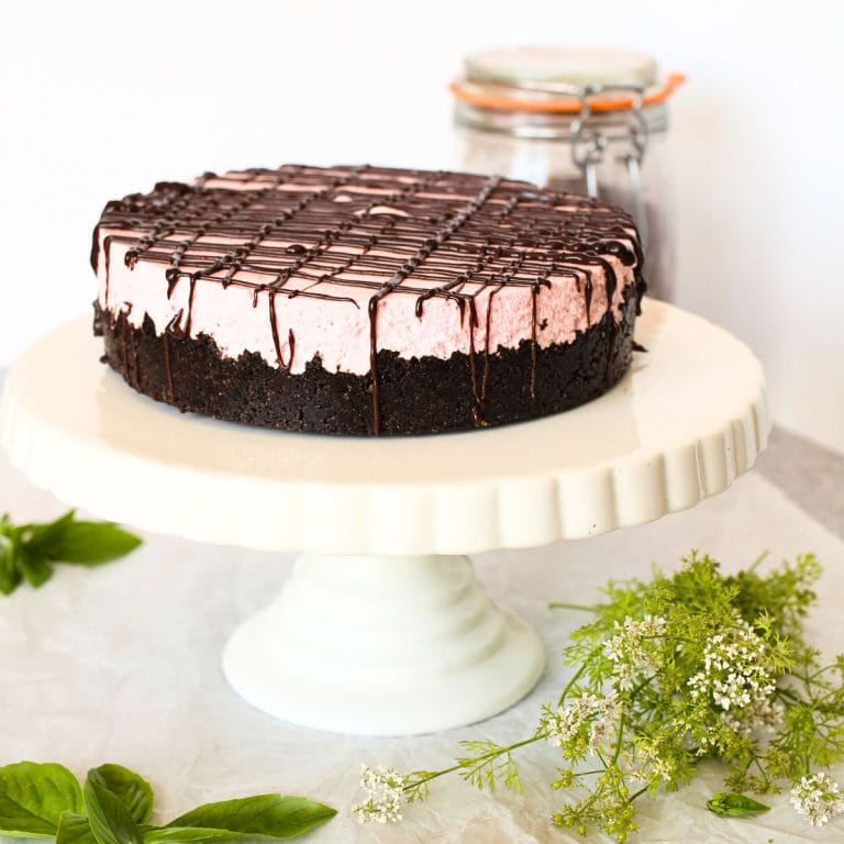 front view of no-bake keto strawberry cheesecake with chocolate drizzle on a serving platter