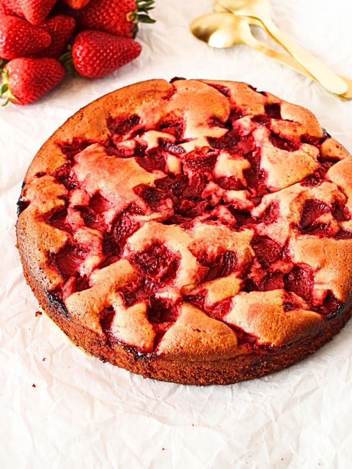 a keto vanilla cake with diced strawberries and an orchid in the background