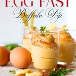 front view of a small glass cup filled with egg fast buffalo dip with parmesan crackers