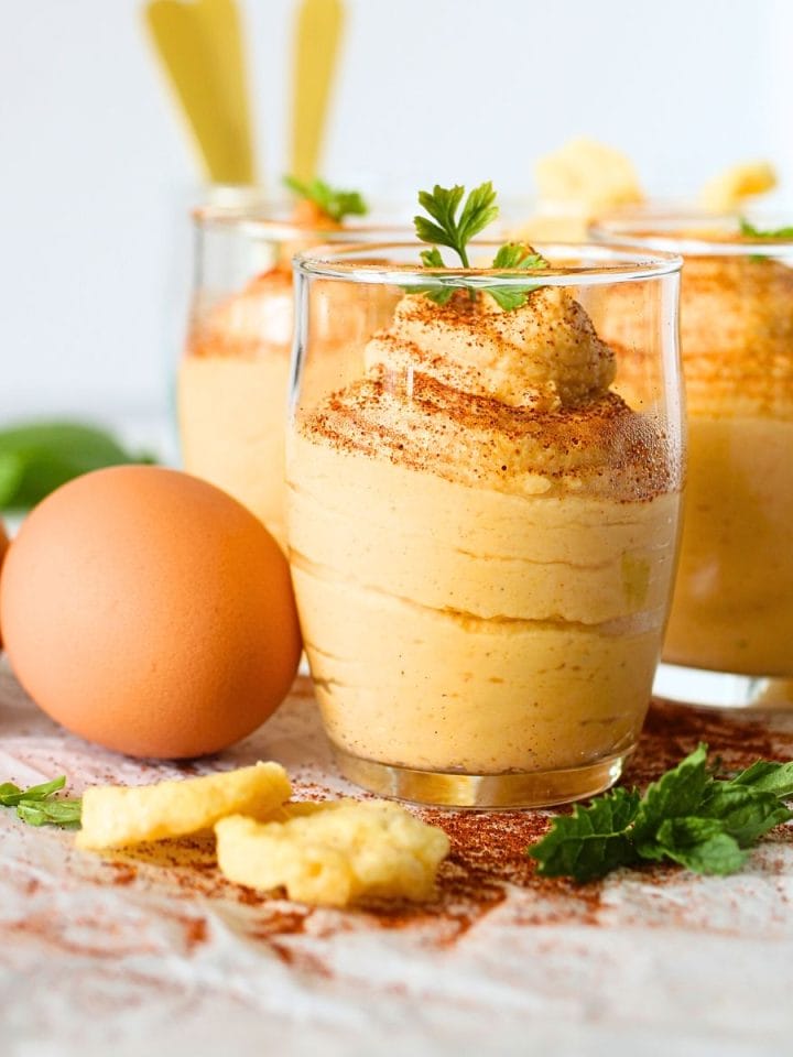 front view of a small glass cup filled with egg fast buffalo dip with parmesan crackers