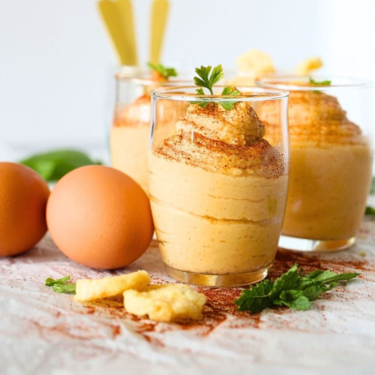 front view of a small glass cup filled with egg fast buffalo dip with parmesan crackers