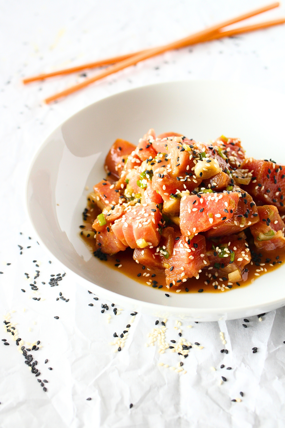 top view of high protein poke bowl with ahi tuna, soy, ginger, scallions and chopsticks