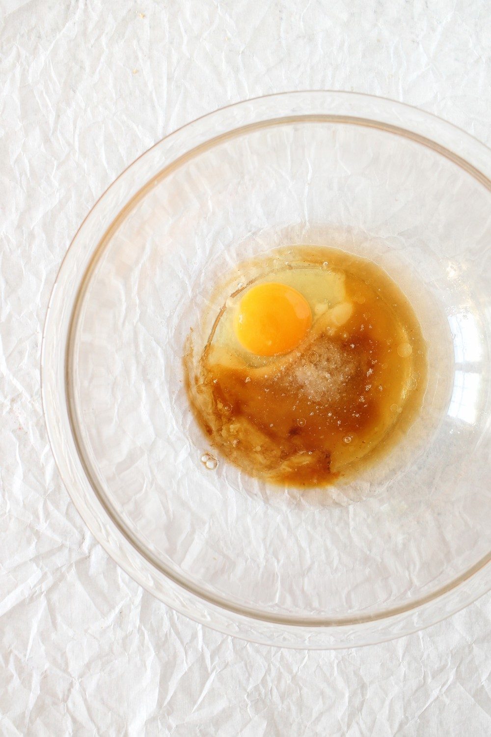 top view of mixing bowl for using egg, coconut oil and sugar-free maple syrup