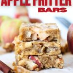 front view of keto apple fritter bars stacked on top of each other with apples and cinnamon sticks in the background