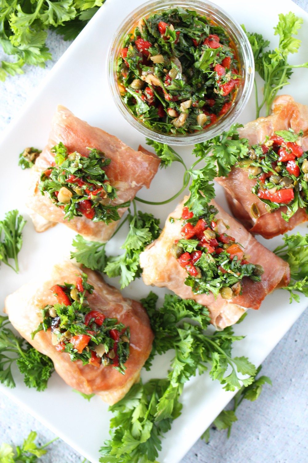 keto prosciutto-wrapped salmon with herb sauce on a serving plate