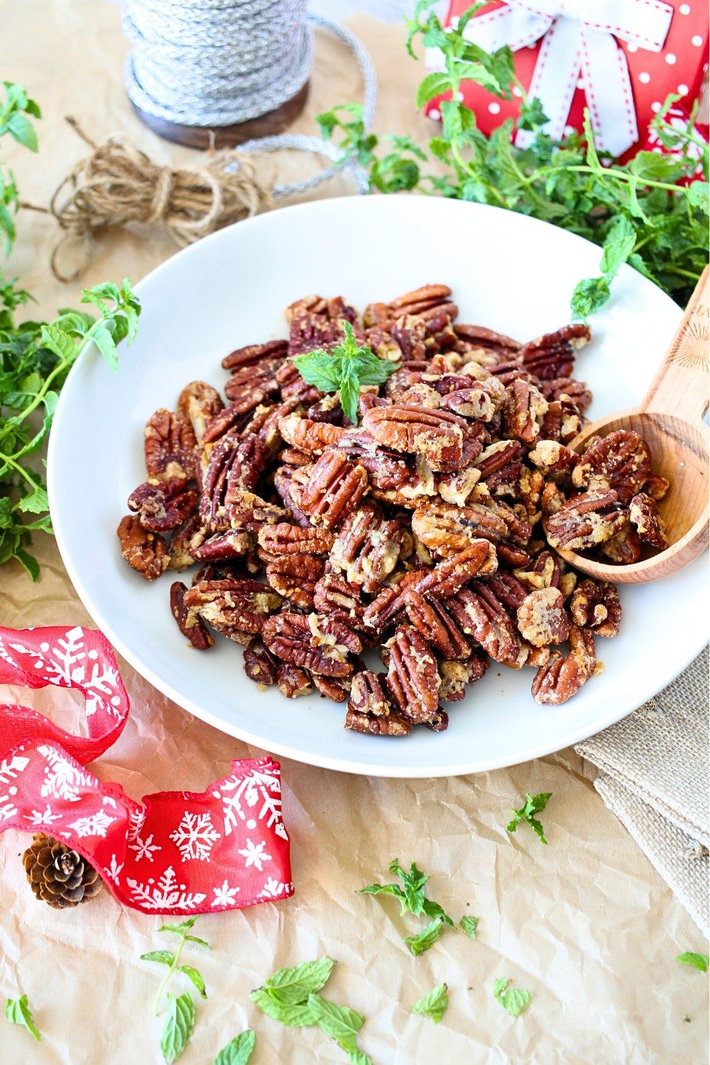Keto garlic parmesan roasted pecans in a bowl with a wooden spoon.