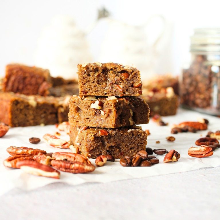 keto coffee nut blondies that are high in fiber stacked on top of each other with nuts scattered about